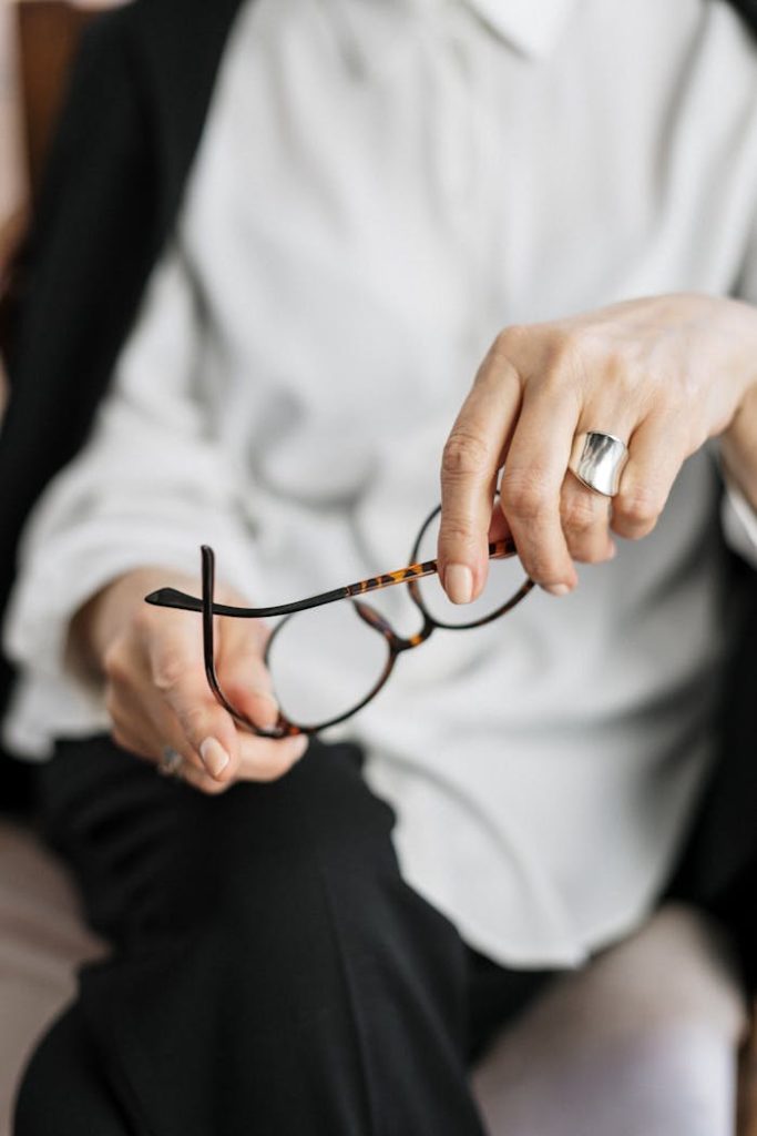 pexels photo 4098340 Close-up of a woman holding glasses, symbolizing thought and professionalism.